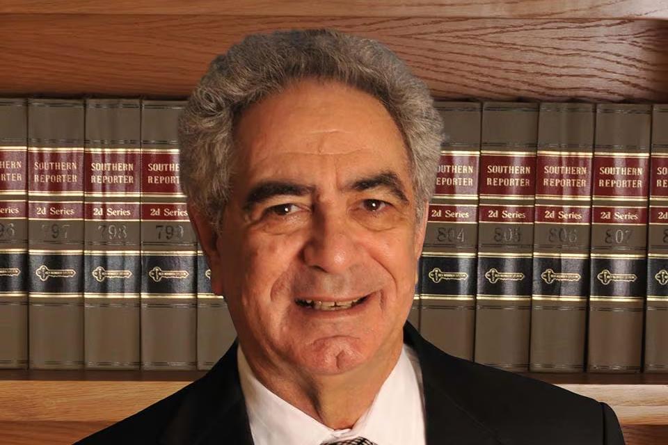 Robert Mayeri, standing in front of shelves of law reports