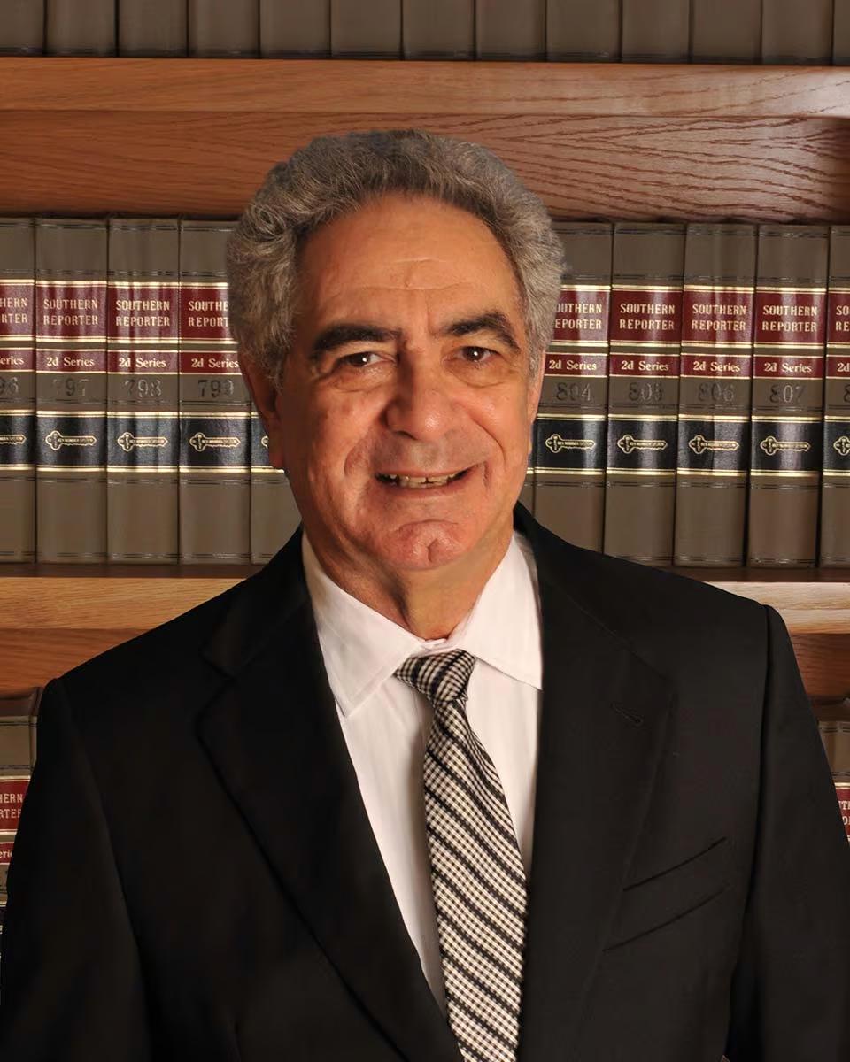 Robert Mayeri, standing in front of shelves of law reports